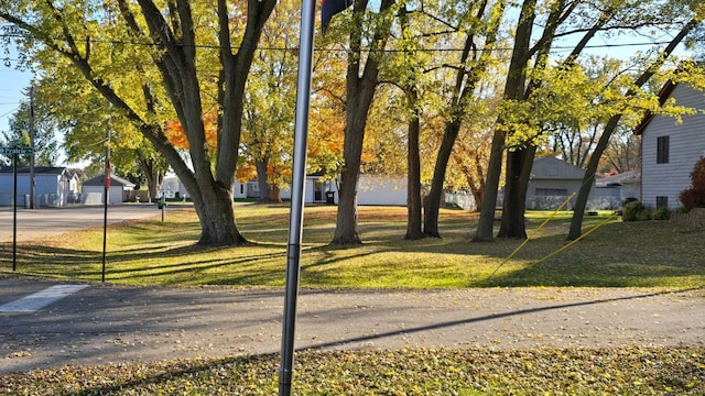 view of home's community with a lawn and an outdoor structure