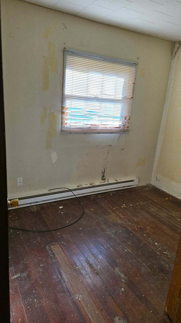 spare room featuring hardwood / wood-style floors and baseboard heating