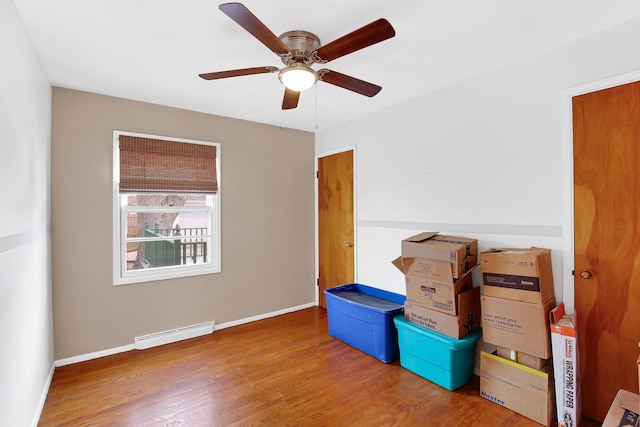 storage featuring a baseboard heating unit and ceiling fan