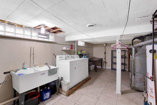 laundry area featuring sink, washing machine and dryer, and light tile patterned flooring