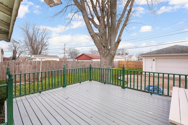 deck with a garage, an outdoor structure, and a lawn