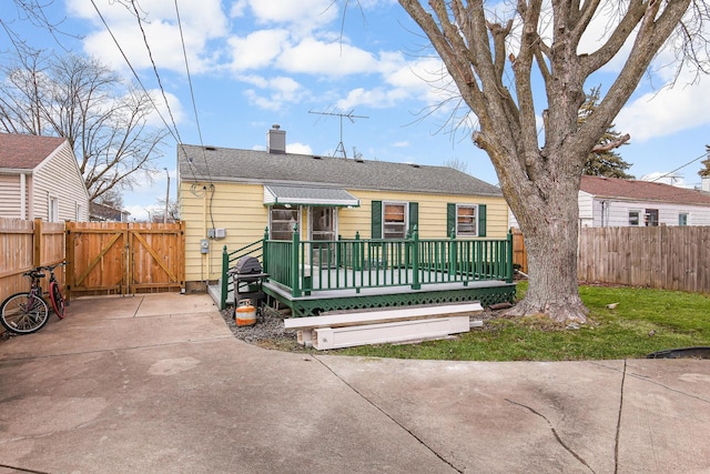 view of front of house with a deck and a front lawn