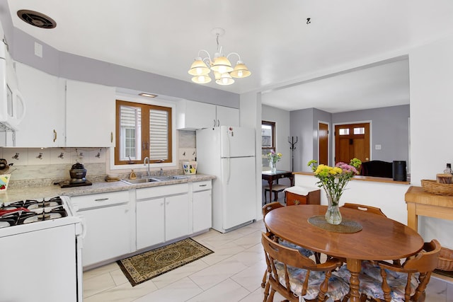 kitchen featuring pendant lighting, tasteful backsplash, white cabinetry, sink, and white appliances