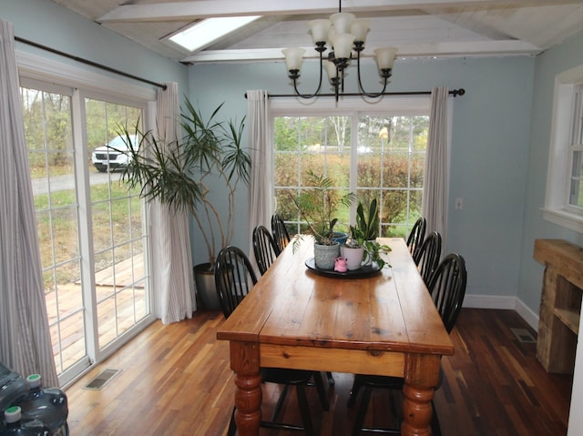 dining space with hardwood / wood-style floors, a chandelier, and lofted ceiling with skylight