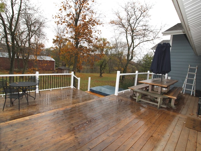 wooden terrace featuring a lawn