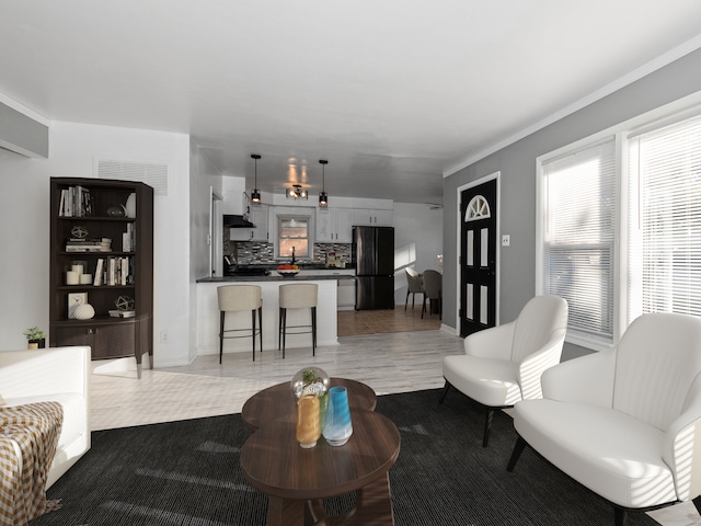 living room featuring ornamental molding and a wealth of natural light