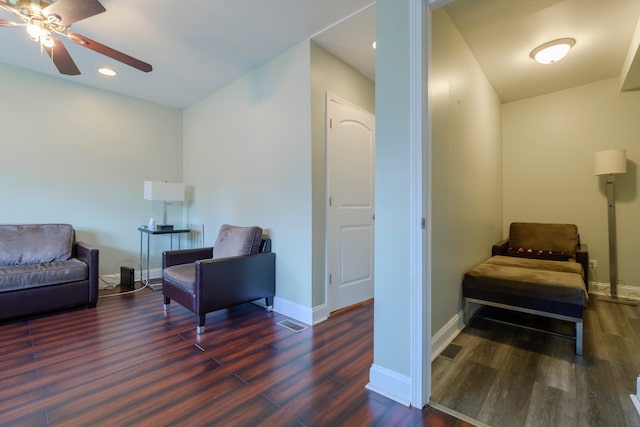 living area with dark wood-type flooring and ceiling fan