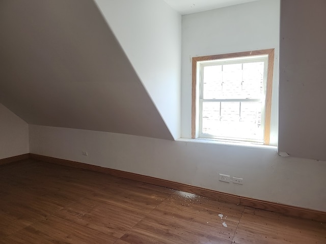 bonus room with vaulted ceiling and dark hardwood / wood-style floors