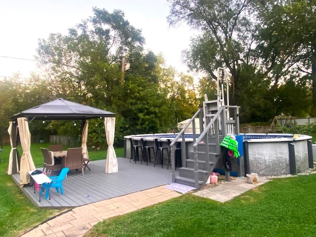 view of playground with a gazebo, a pool side deck, and a yard