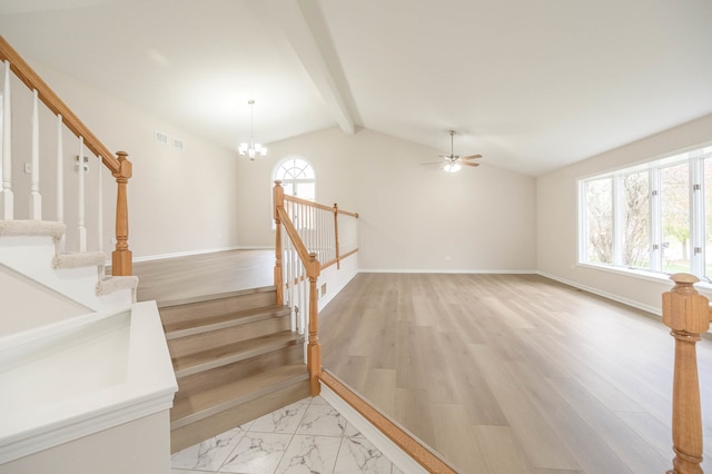 staircase featuring hardwood / wood-style floors, lofted ceiling with beams, and a wealth of natural light