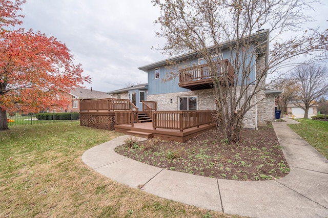 back of house with a wooden deck and a lawn