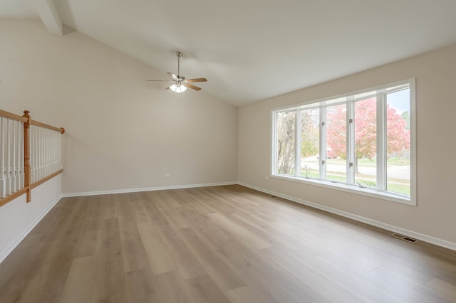 empty room featuring ceiling fan, lofted ceiling with beams, and light hardwood / wood-style flooring