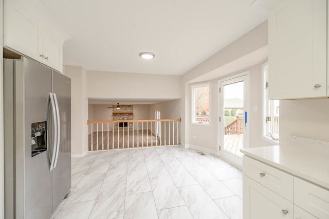 kitchen with stainless steel refrigerator with ice dispenser and white cabinets