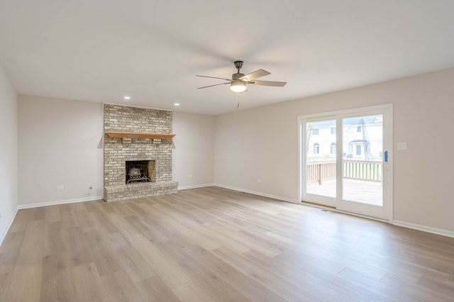 unfurnished living room featuring a brick fireplace, light wood-type flooring, and ceiling fan