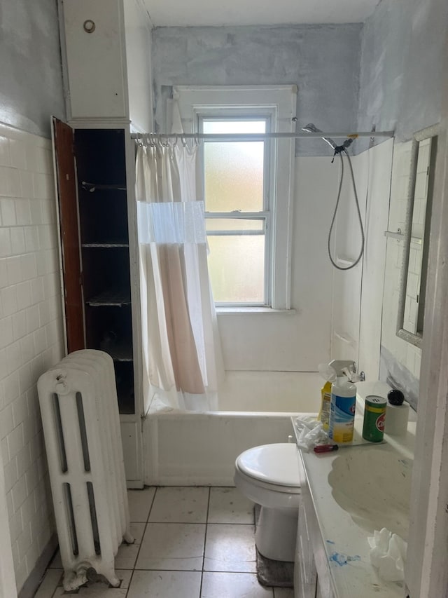 full bathroom featuring radiator heating unit, toilet, shower / bath combo with shower curtain, vanity, and tile patterned floors