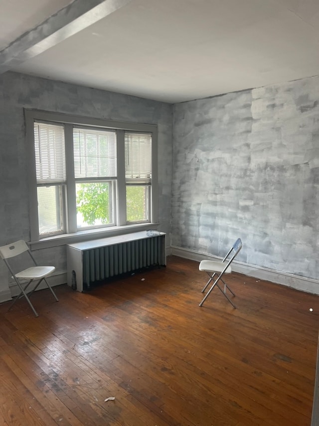 empty room featuring radiator and dark wood-type flooring