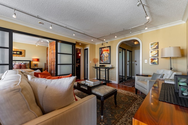 living room featuring ornamental molding, hardwood / wood-style floors, track lighting, and a textured ceiling