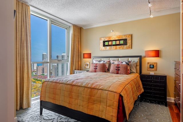 bedroom with a textured ceiling, multiple windows, and hardwood / wood-style flooring