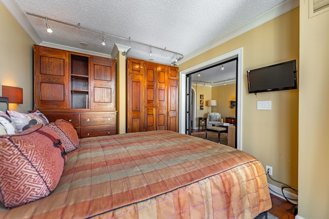 1212 N Lasalle Dr Unit 2404, Chicago, IL 60610 - bedroom featuring rail lighting, a textured ceiling, crown molding, and baseboards