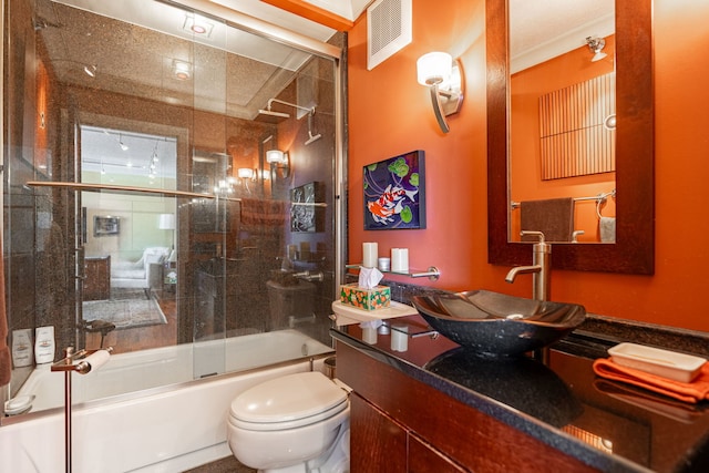 full bathroom with toilet, bath / shower combo with glass door, and vanity