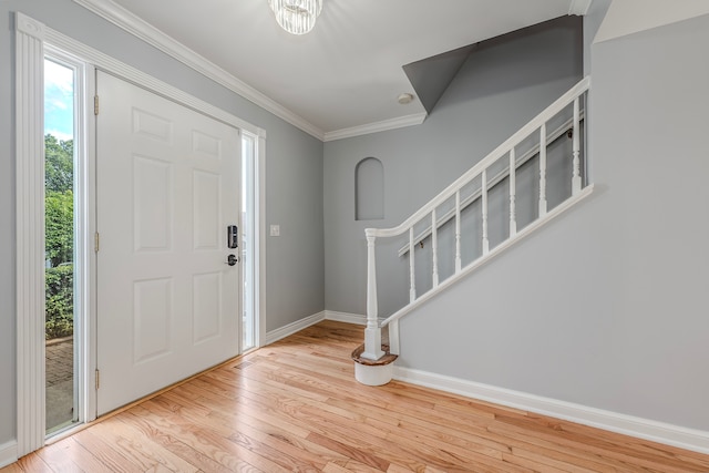 entrance foyer featuring crown molding and light hardwood / wood-style floors