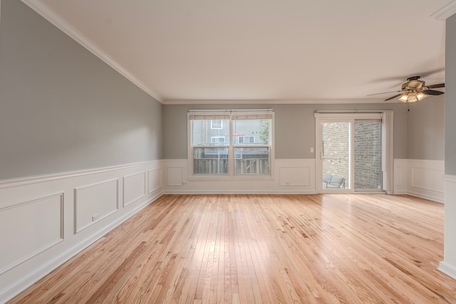 spare room featuring crown molding, light wood-type flooring, and ceiling fan