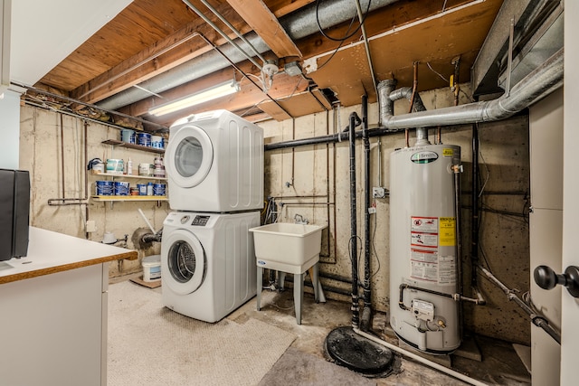 laundry area featuring water heater and stacked washer and clothes dryer