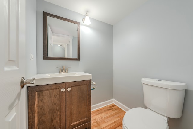 bathroom featuring vanity, toilet, and hardwood / wood-style floors