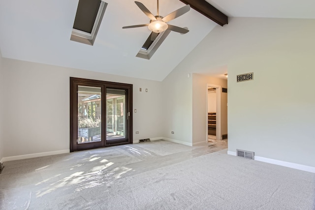 empty room featuring light carpet, beam ceiling, ceiling fan, high vaulted ceiling, and a skylight