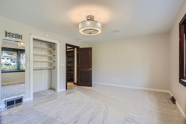 empty room with built in shelves and light colored carpet