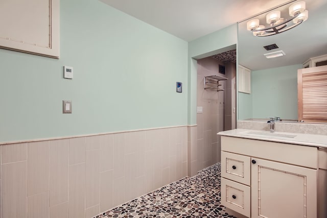 bathroom with vanity and tiled shower