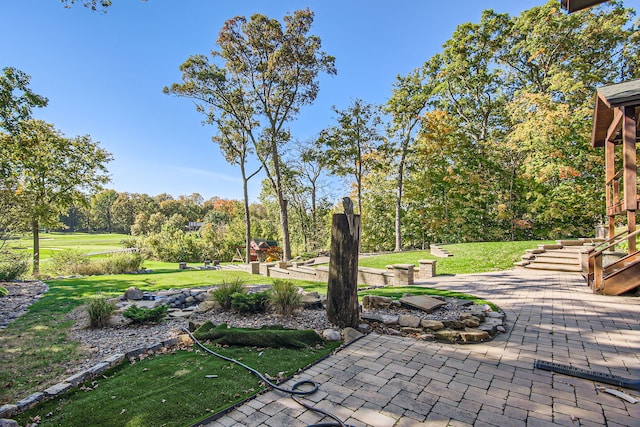 view of property's community with a patio area and a lawn