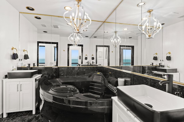 bathroom with vanity, a notable chandelier, and a healthy amount of sunlight