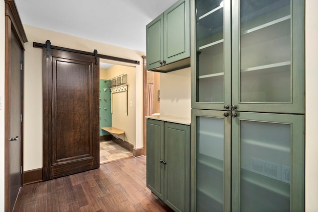 interior space with dark hardwood / wood-style floors and a barn door