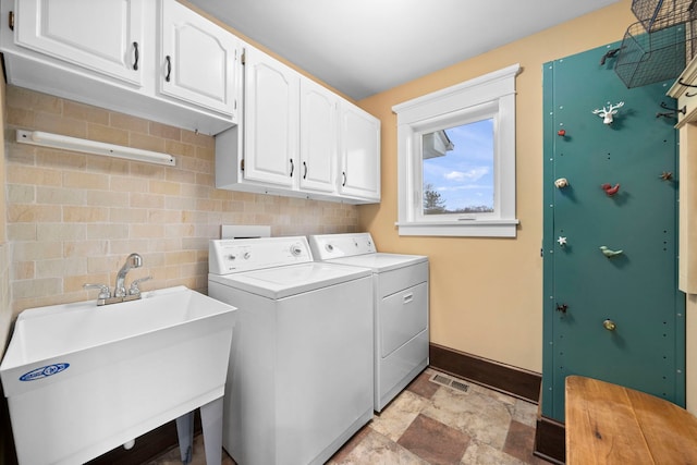 laundry room featuring sink, cabinets, and separate washer and dryer