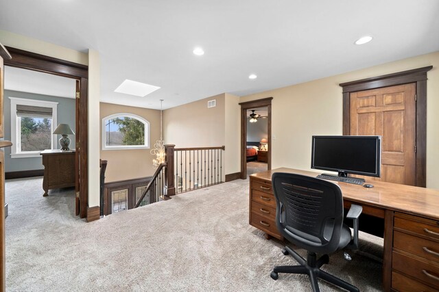 office area with light colored carpet and a skylight