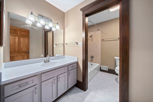 full bathroom with tile patterned floors, toilet, tiled shower / bath, and vanity