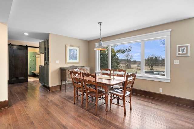 dining area featuring dark wood-type flooring and a barn door