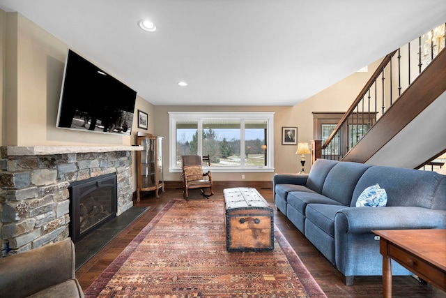 living room featuring dark hardwood / wood-style floors and a stone fireplace