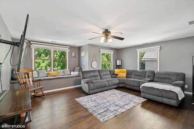 living room featuring dark wood-type flooring, ceiling fan, and a healthy amount of sunlight