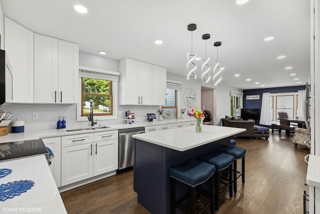 kitchen with stainless steel dishwasher, sink, and white cabinetry