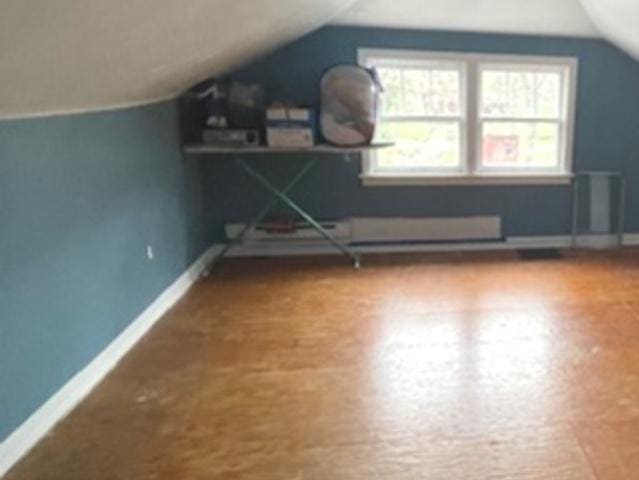 additional living space featuring lofted ceiling and baseboards