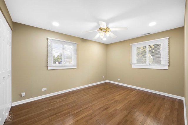 empty room featuring dark hardwood / wood-style flooring and ceiling fan