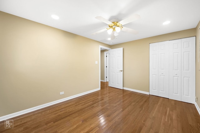 unfurnished bedroom featuring hardwood / wood-style floors, ceiling fan, and a closet