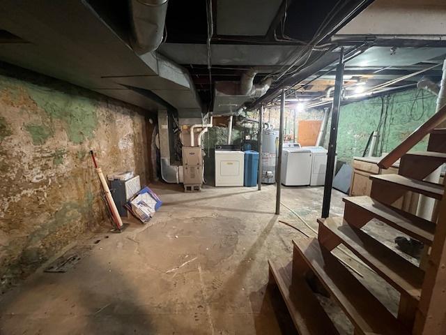 basement with gas water heater, independent washer and dryer, and heating unit