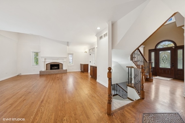 living room featuring light hardwood / wood-style flooring and a towering ceiling