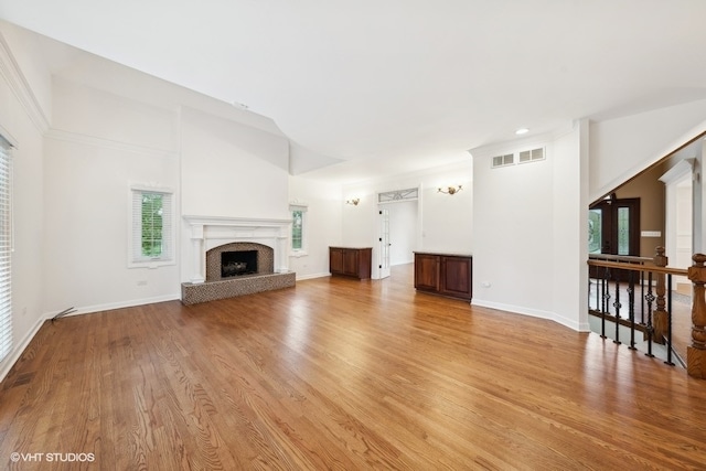 unfurnished living room featuring light hardwood / wood-style floors and a high ceiling