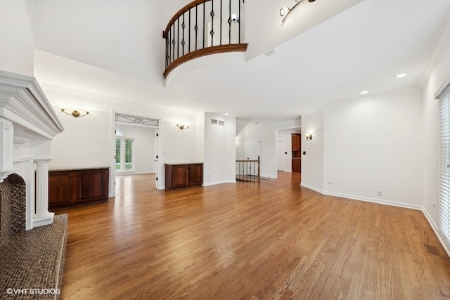 living room featuring ornate columns, crown molding, and light wood-type flooring