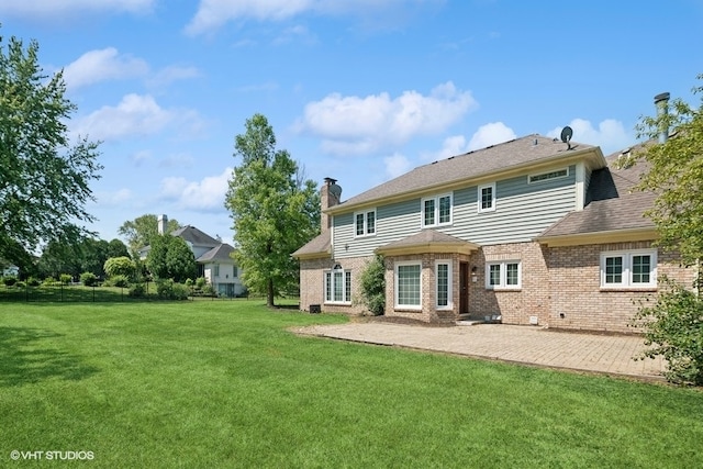 back of property with a patio area and a lawn