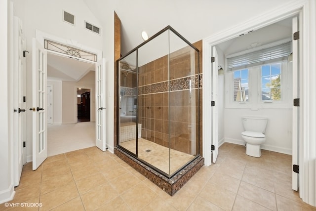 bathroom with tile patterned floors, vaulted ceiling, toilet, and an enclosed shower